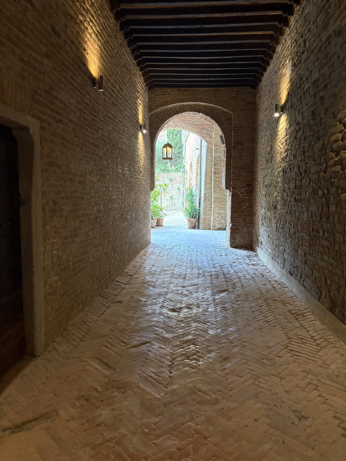 The covered passage today, with the wooden beams, the wall lights and the herringbone floor