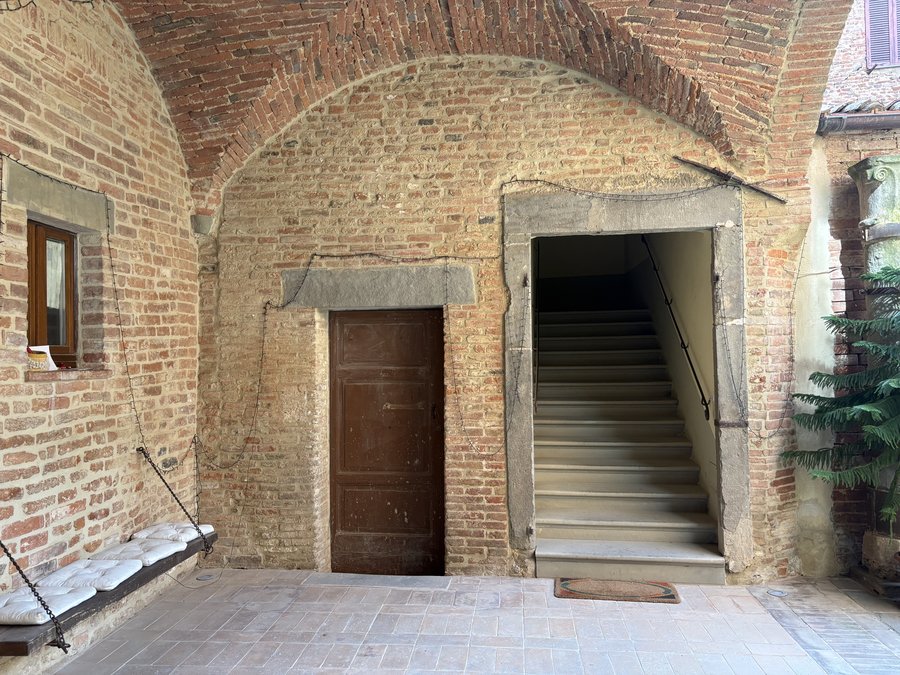 The wooden door and the staircase beneath the brick vault
