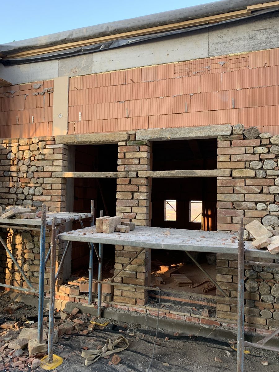 New brick masonry on the upper floor, with the scaffolding