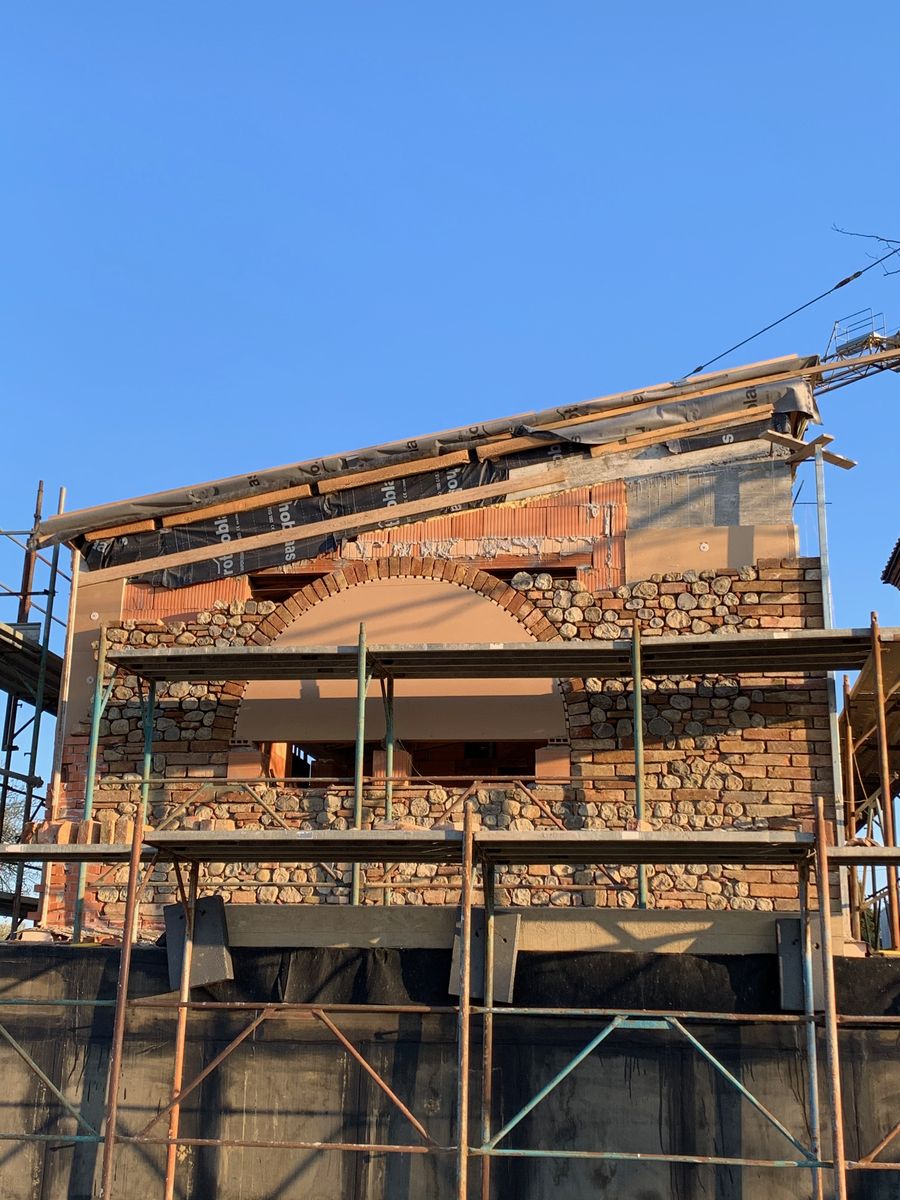 Stone and brick façade with the scaffolding, during the stitching of the masonry
