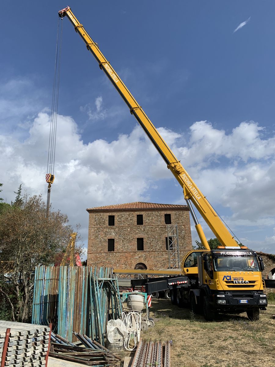 Site crane in front of the stone farmhouse, with the scaffolding ready
