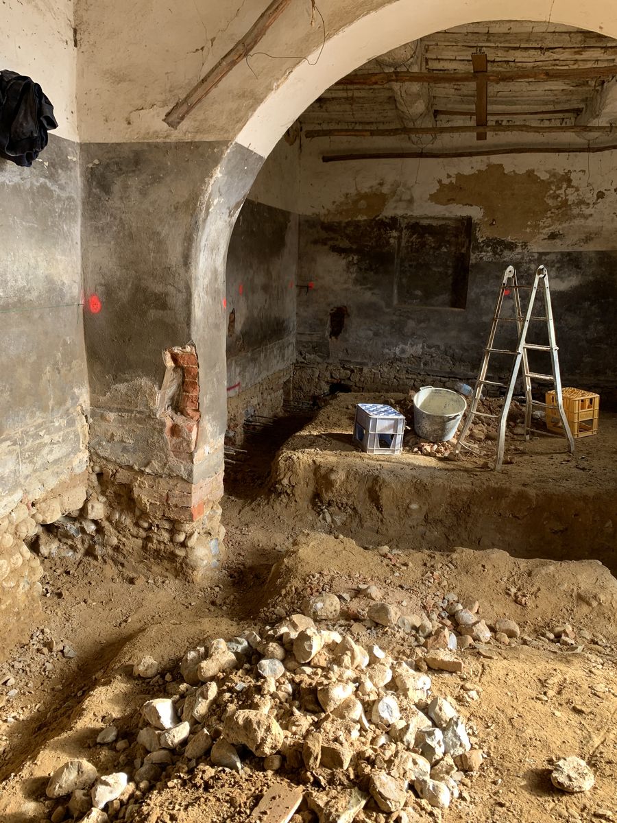 Excavation inside a room with a masonry arch, for the new floor