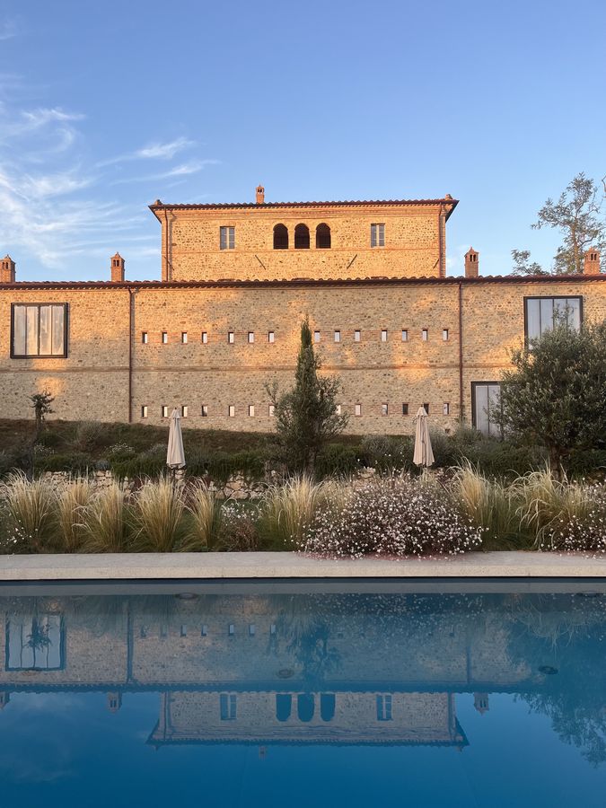 The farmhouse at sunset reflected in the pool