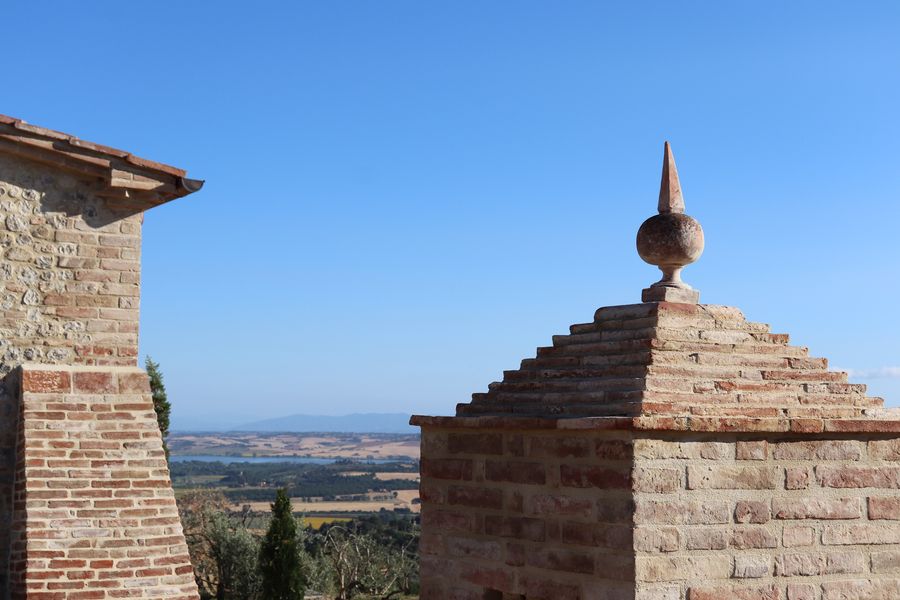 The brick well with its pinnacle, at the edge of the garden