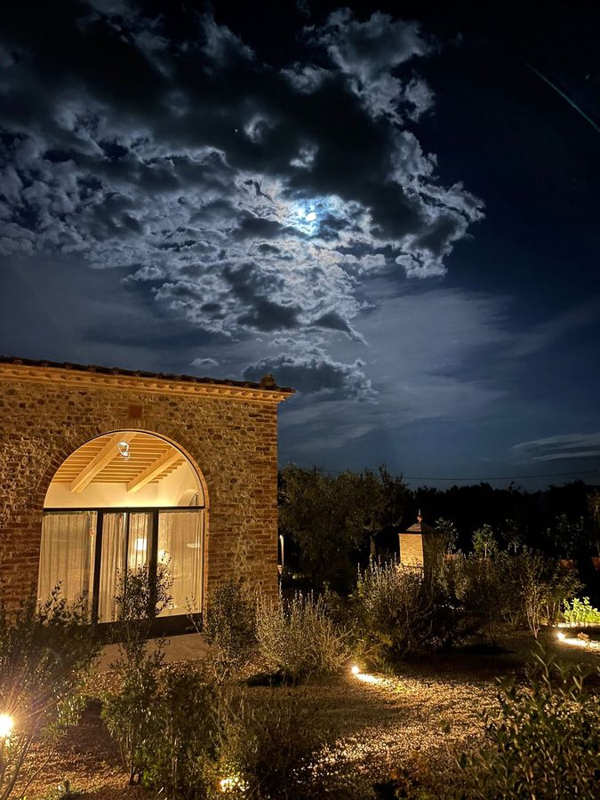 The glazed loggia lit up in the evening, under a cloudy sky