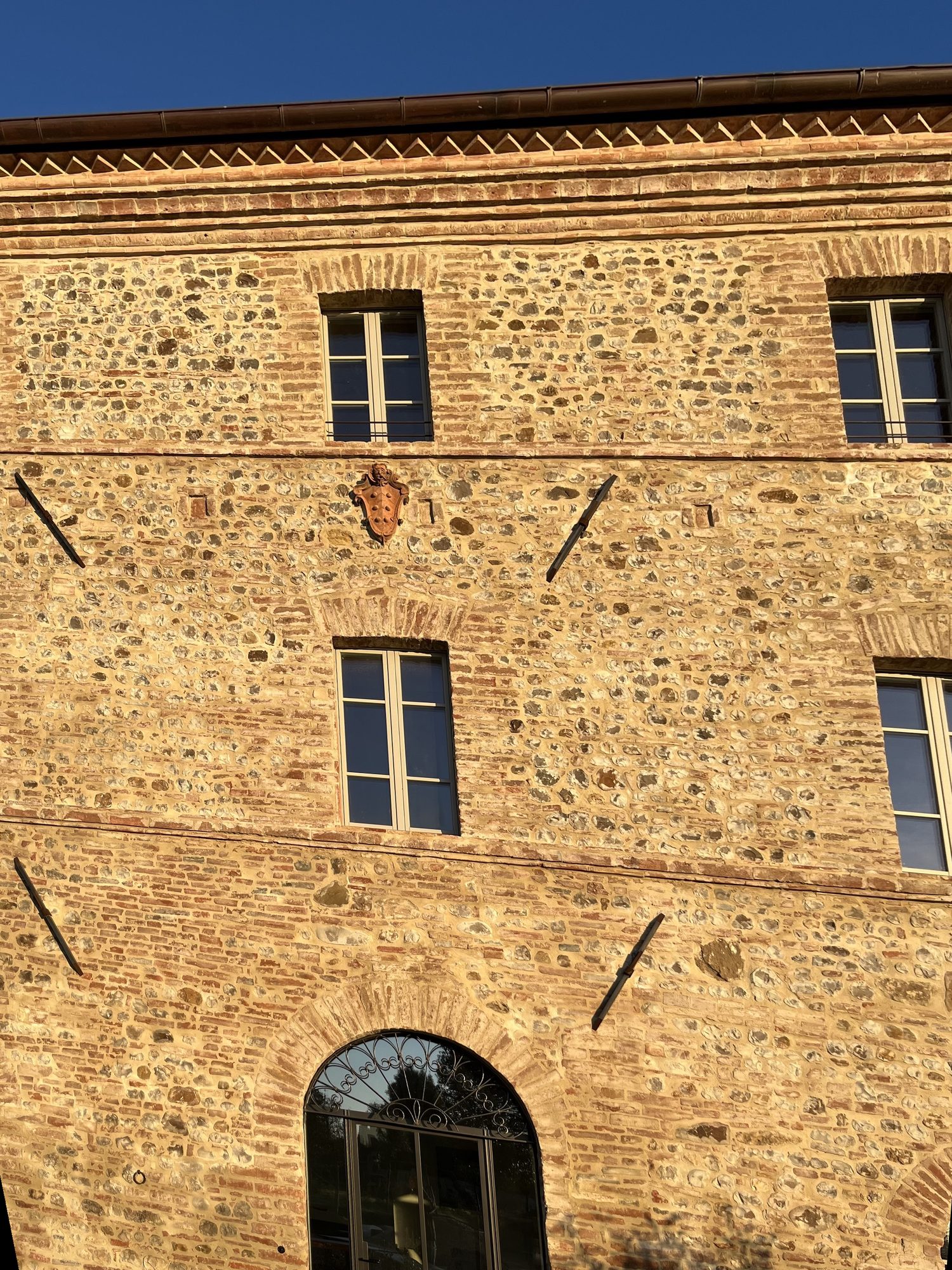 The façade of Ca' Litardo today, with the restored masonry, the coat of arms and the glazed arched portal