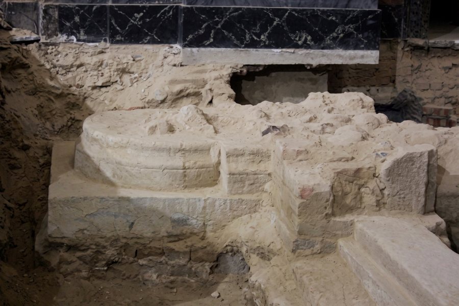 Basamenti in pietra riemersi durante lo scavo, sotto il gradino di marmo nero