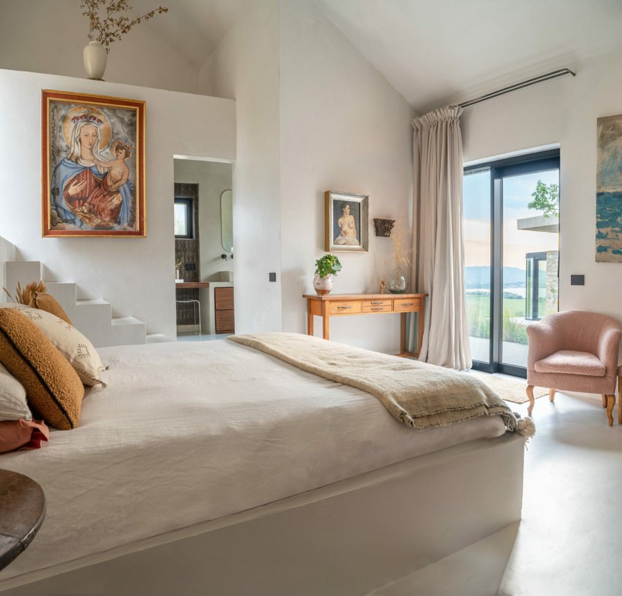 The bedroom with the pitched ceiling and the French window onto the landscape
