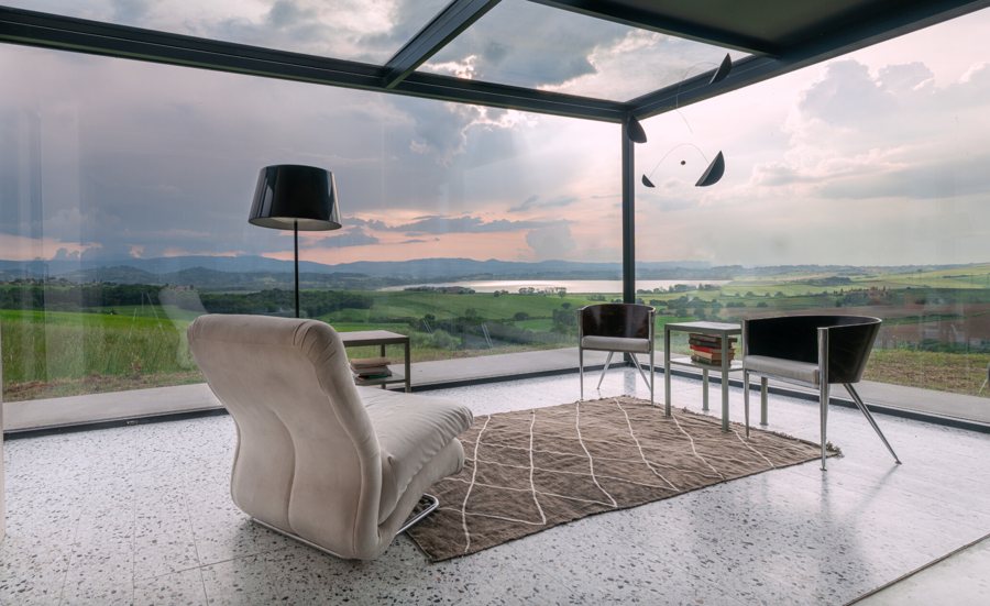 The kitchen with the veined marble island and the ribbon window overlooking the lake