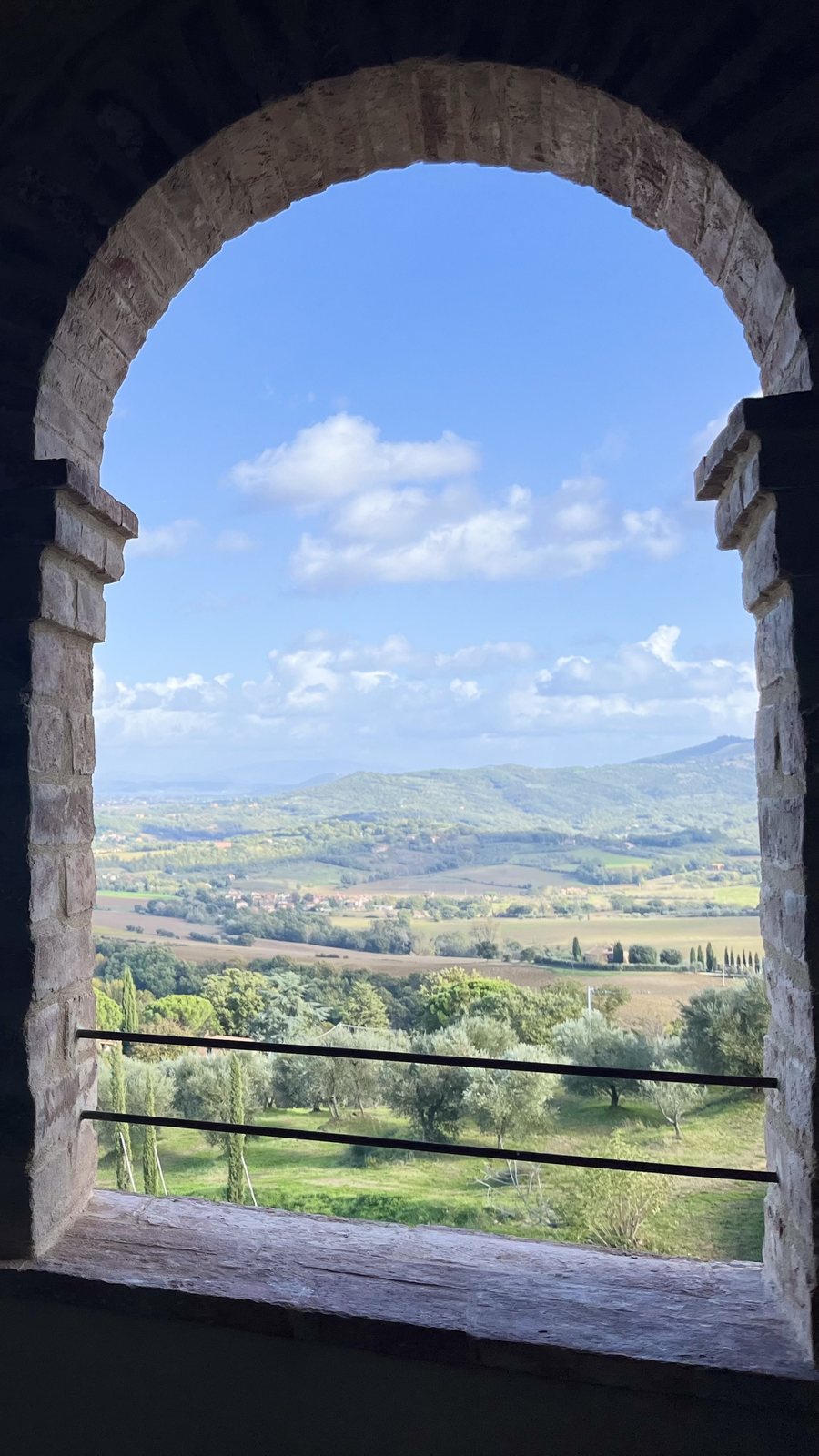 A brick arched loggia overlooking the hills in the morning mist