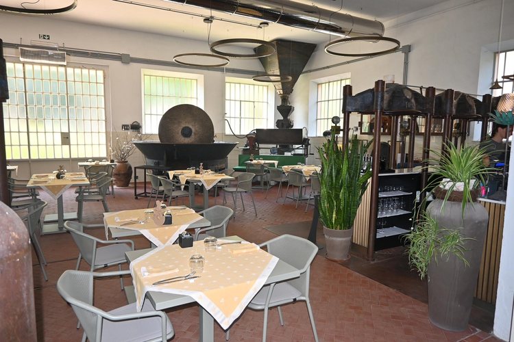 La sala del ristorante con le vecchie presse e la macina dell’oleificio in mostra