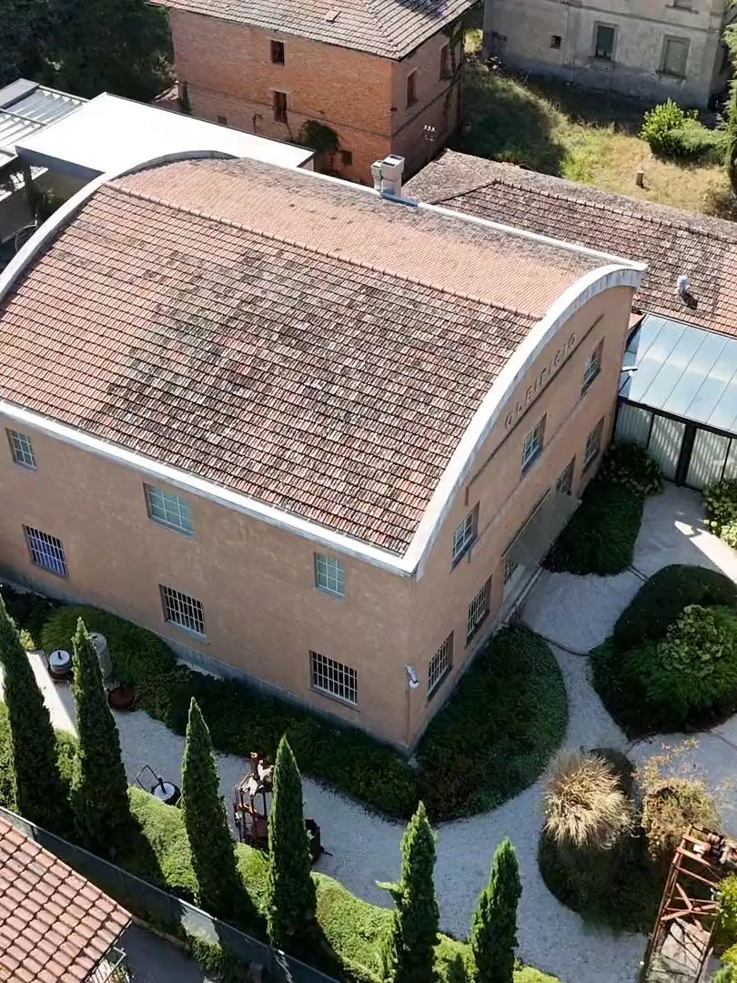 L’ex oleificio visto dal drone, con il tetto ad arco, il giardino e i cipressi
