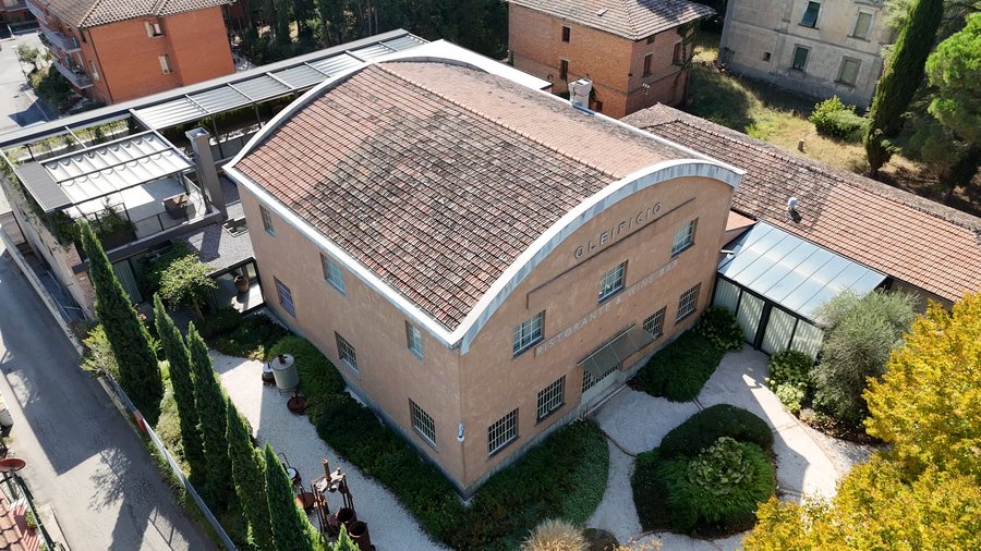 L’oleificio restaurato con il tetto ad arco, il giardino e i cipressi