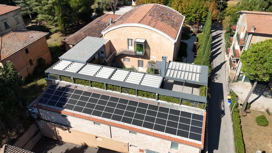 Le terrazze coperte e il fotovoltaico sul nuovo volume, con il retro dell’oleificio
