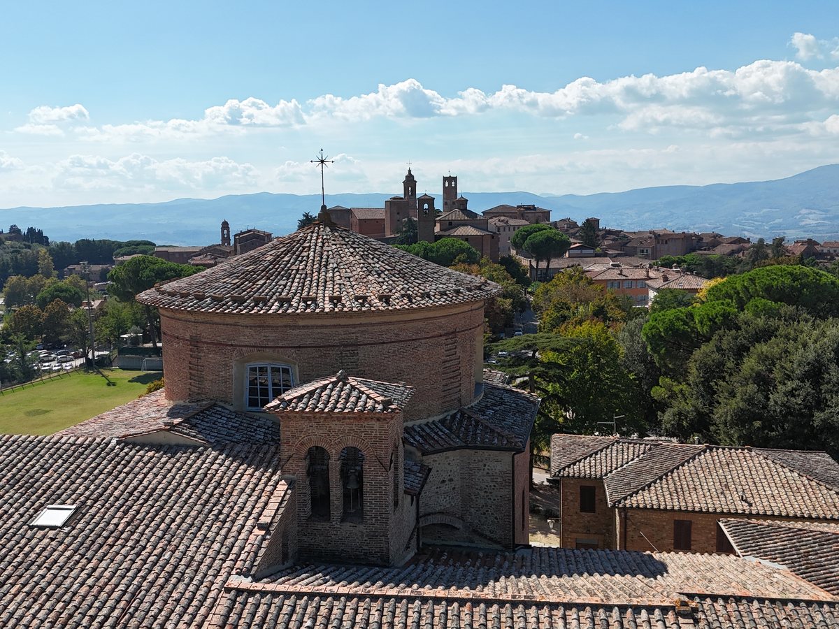 La cupola della chiesa e i tetti in coppi del monastero, con le torri di Città della Pieve sullo sfondo