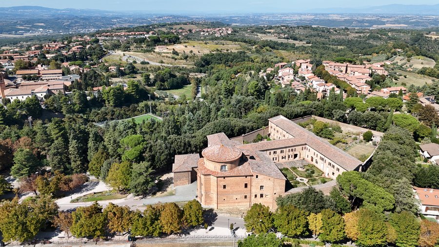 Il monastero e la chiesa nel verde, con la campagna sullo sfondo