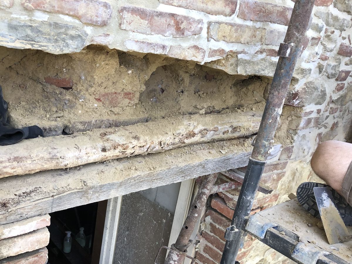 Il vecchio architrave in legno ammalorato sopra una porta, prima della sostituzione