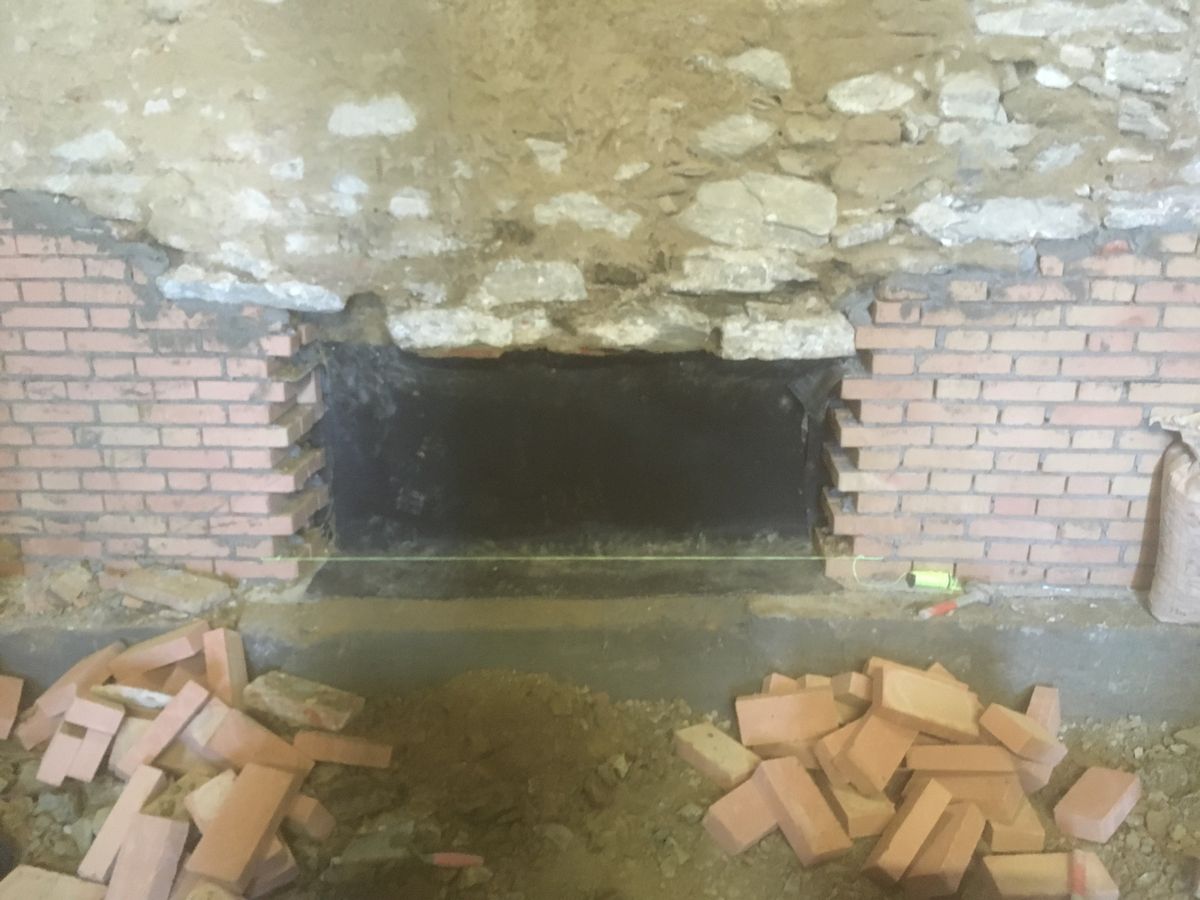 Apertura ricostruita in mattoni sotto un arco in pietra