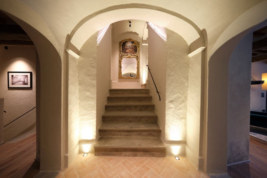 Scala in pietra illuminata sotto una volta ad arco