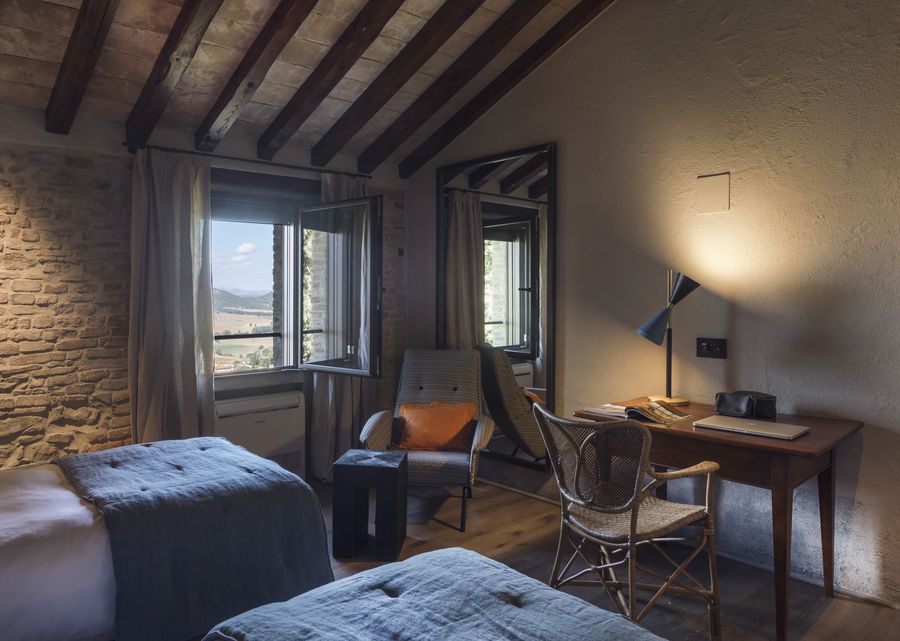 Camera Vera con soffitto a travi, scrivania e finestra sulle colline