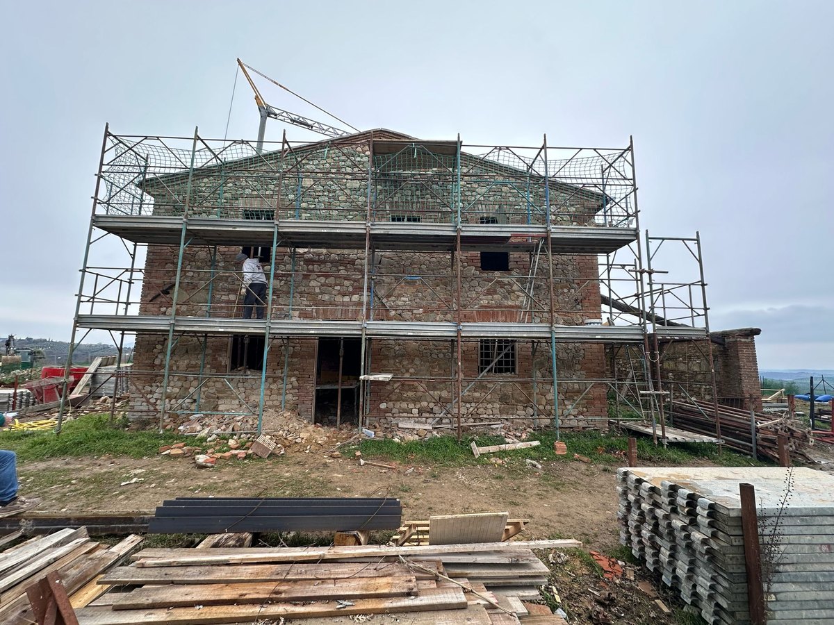 The stone and brick façade covered by scaffolding