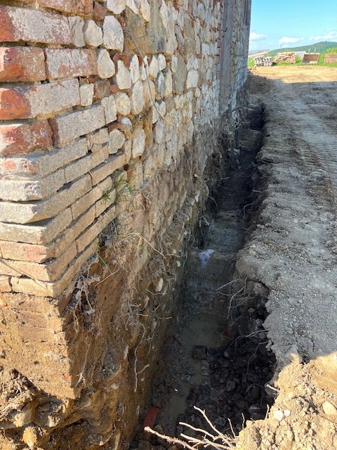 The trench along the wall of the house for the consolidation of the foundations