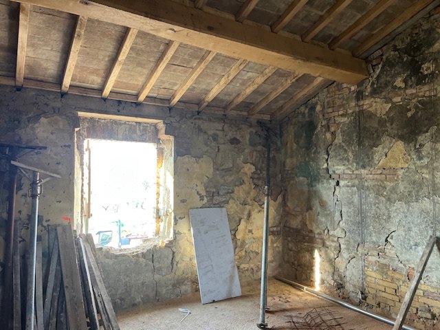 A room with a beam-and-tile ceiling, the window and the props