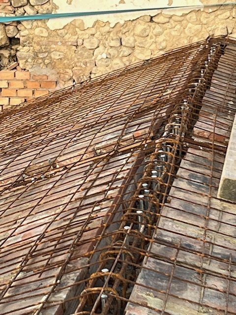 The steel reinforcement laid over the terracotta tiles of the floor
