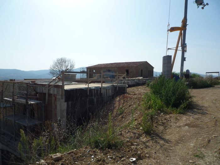 The excavation next to the farmhouse, with the crane