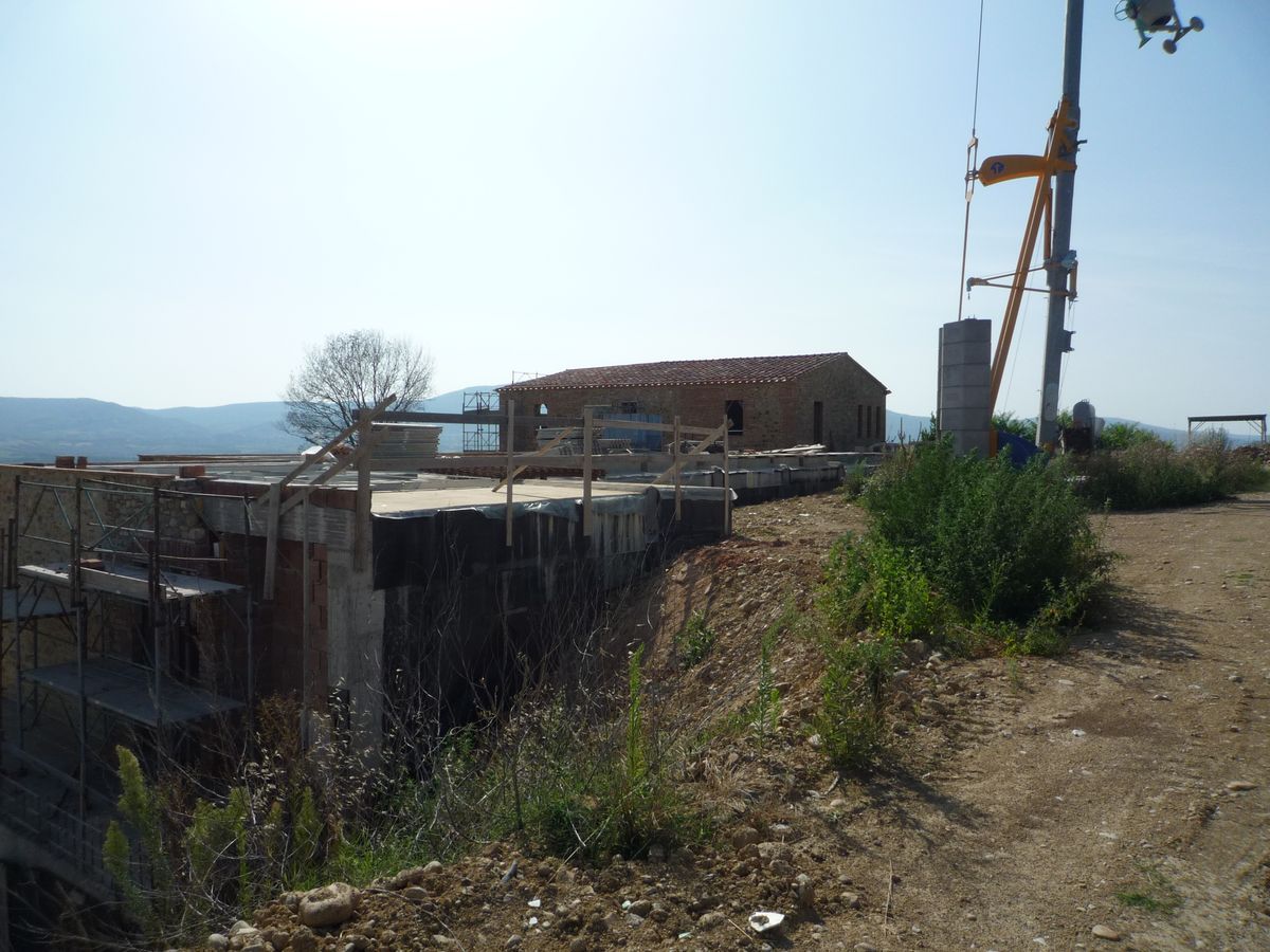Il cantiere con la gru, il casolare e i nuovi volumi