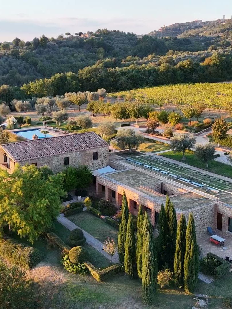 Podere La Vigna Nuova seen from a drone at sunset, among the olive trees