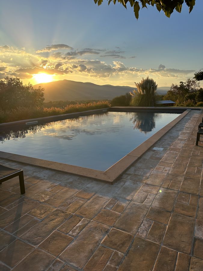 La piscina con il bordo in pietra al tramonto